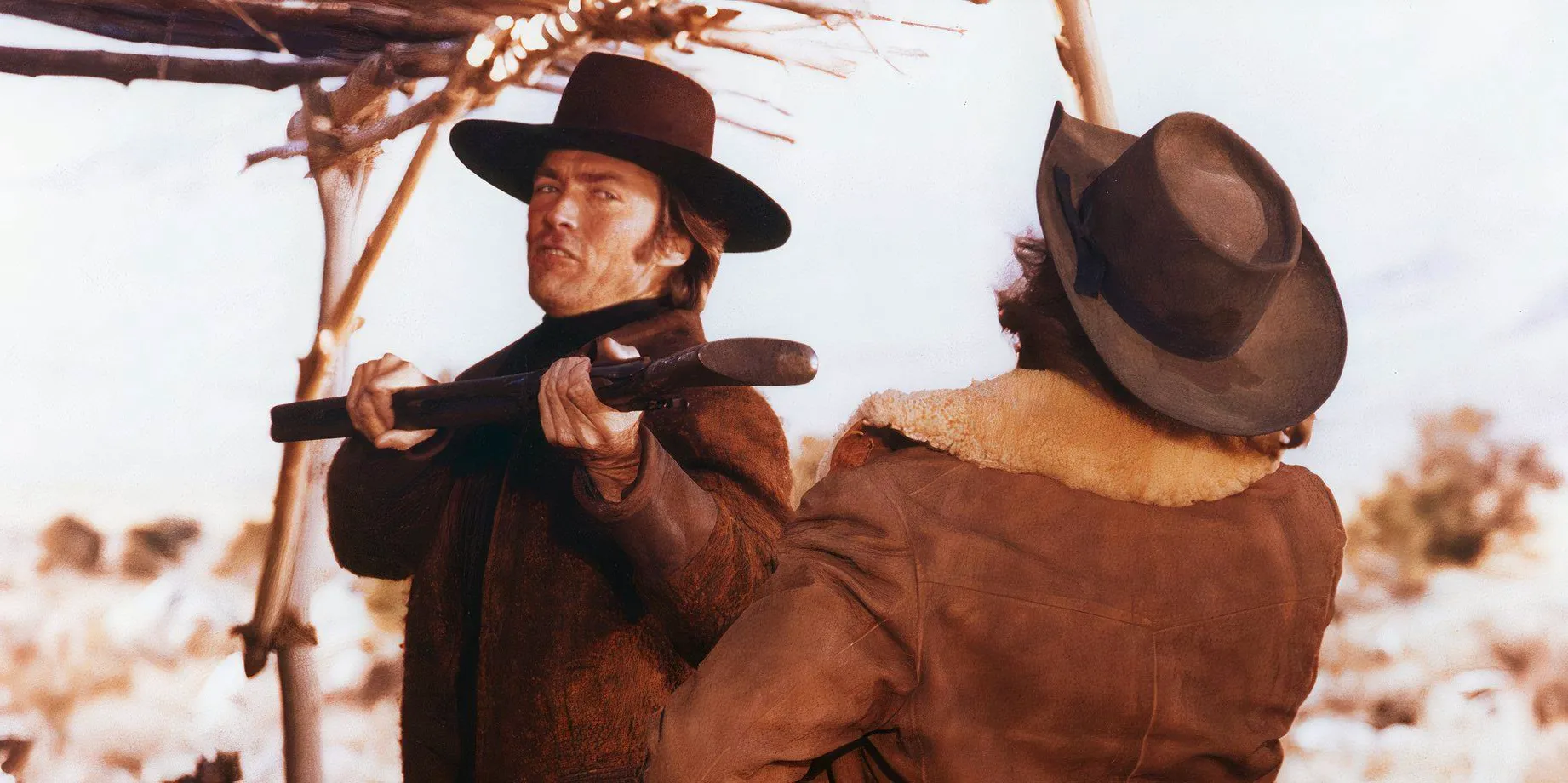 Clint Eastwood in Joe Kidd hitting someone Image