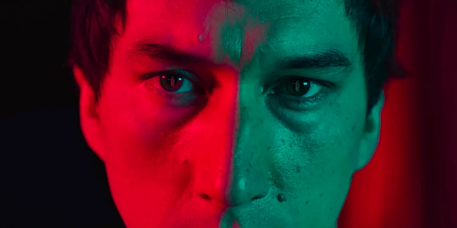 Close-up of Caesar Catalina (Adam Driver) with half of his face illuminated in red in Megalopolis Image