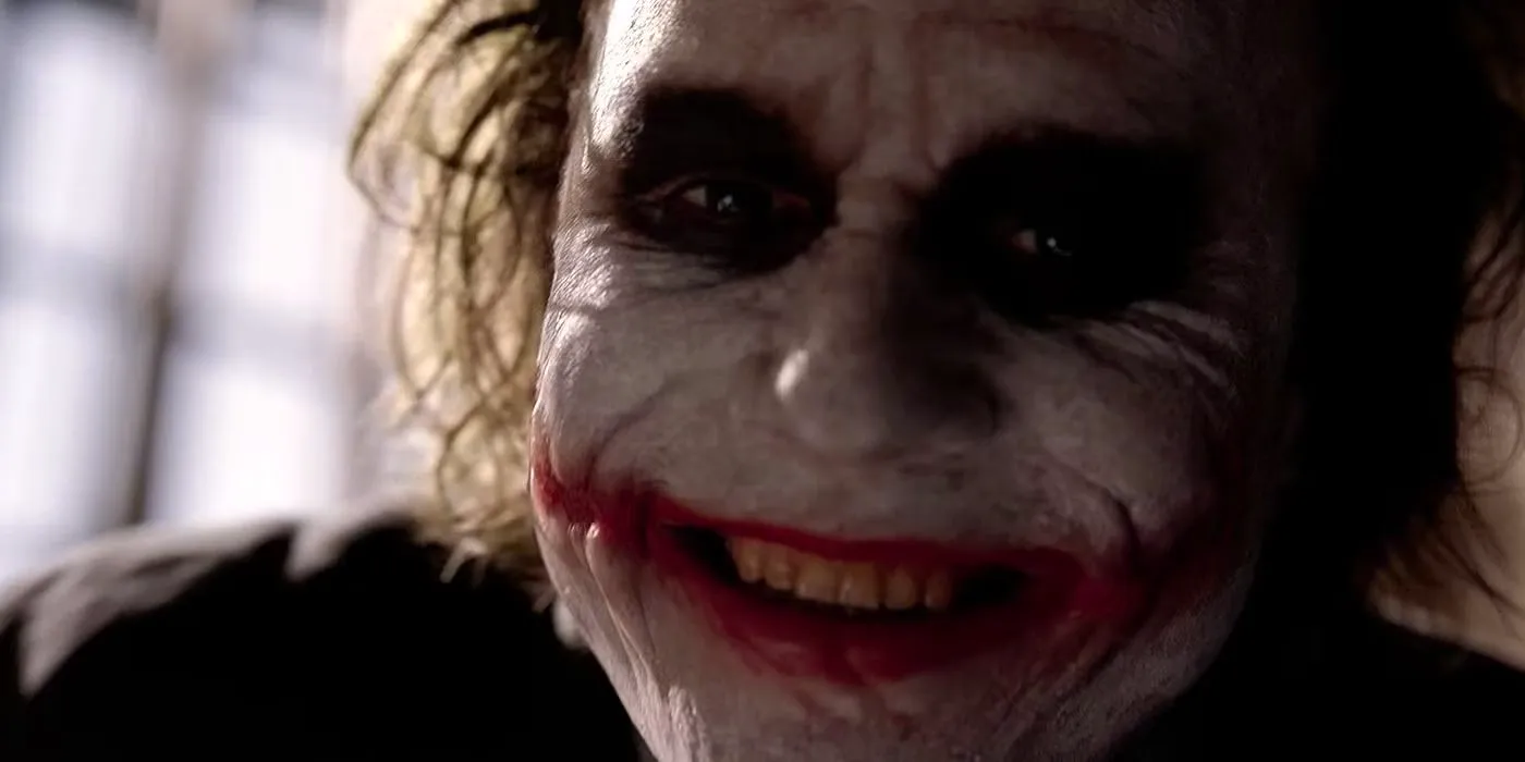 Close-up of Heath Ledger's Joker laughing in The Dark Knight Image