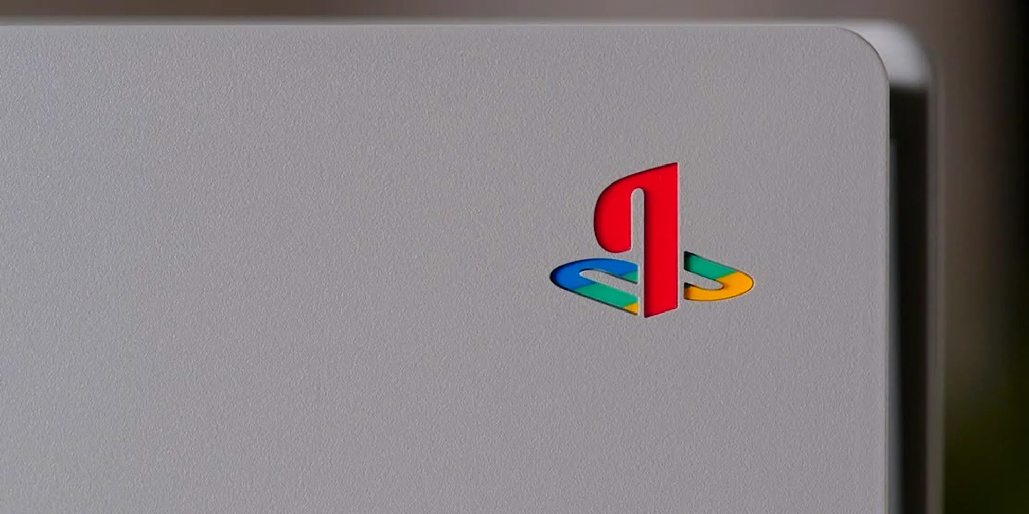 Close-up of the 30th anniversary PS5 limited edition console, modelled after the original PS1. Grey cover with the PS logo in primary colors Image