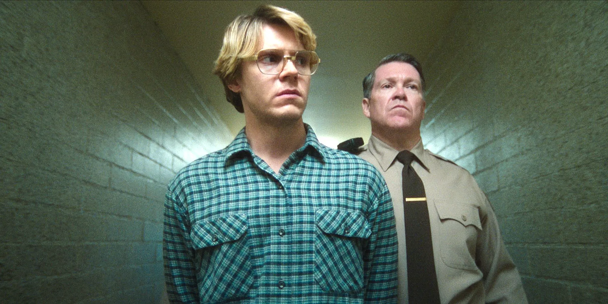 Dahmer is led down a hallway by a police officer in Dahmer Image