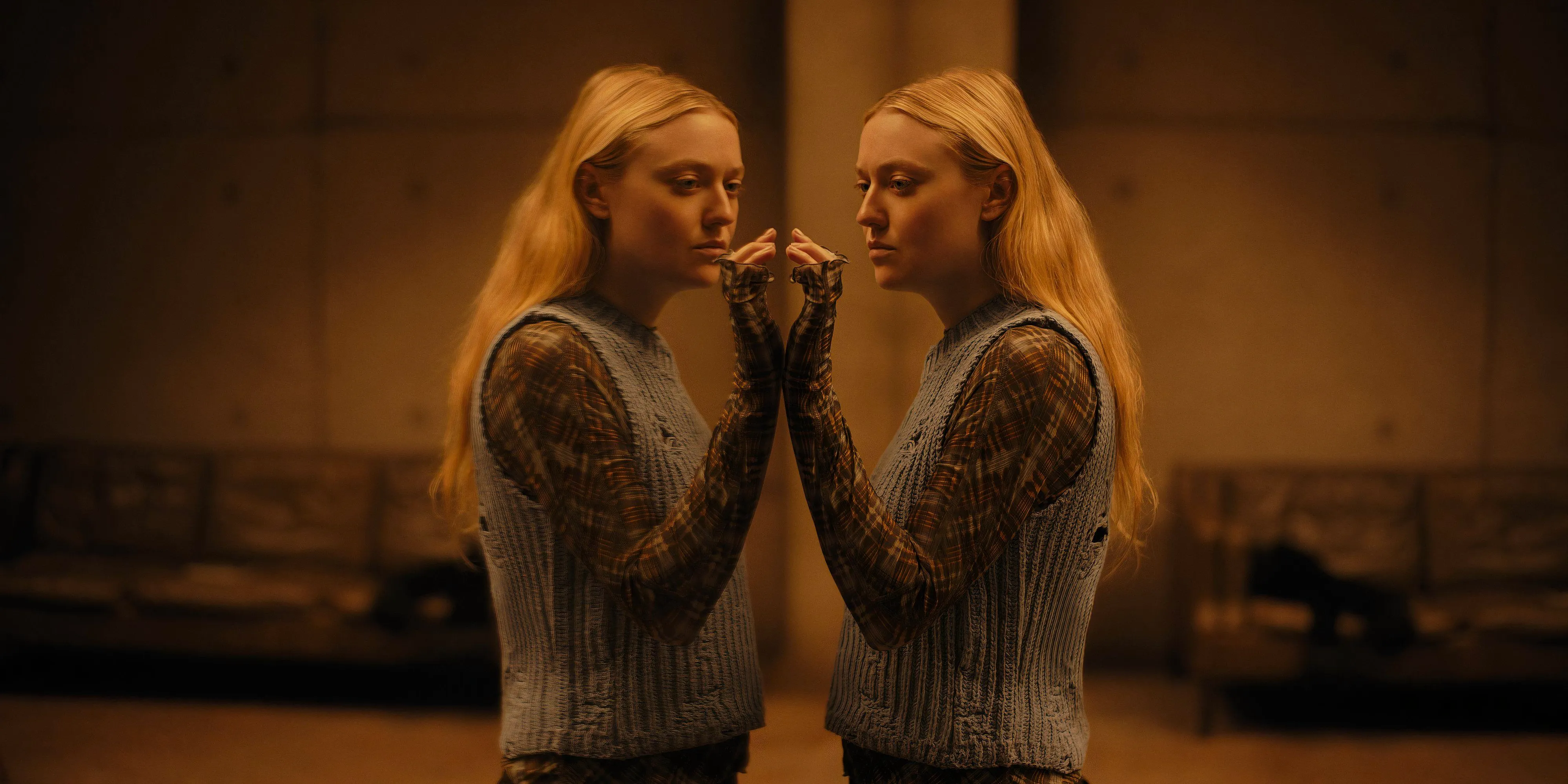 Dakota Fanning holds her hand up to mirror in The Watchers movie still Image