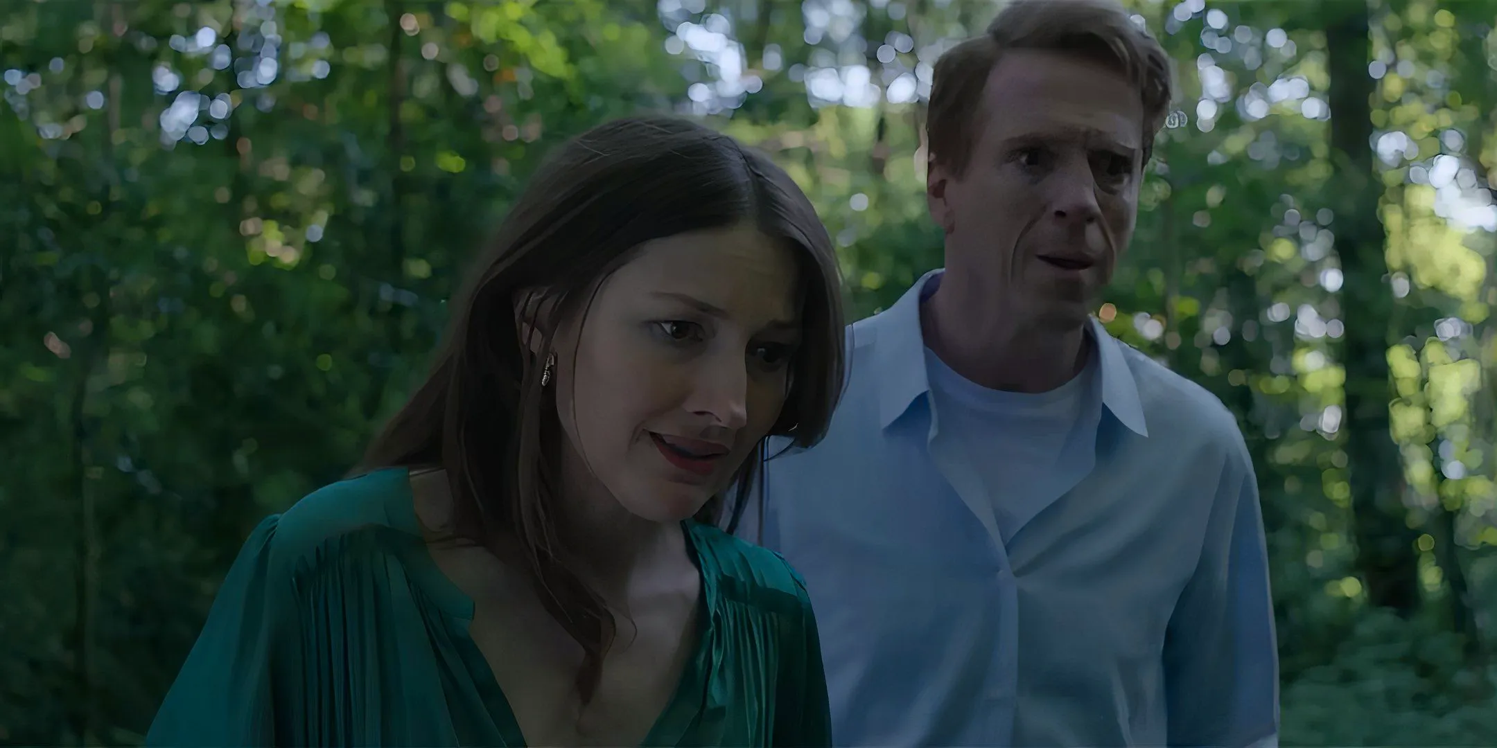 Damian Lewis as Peter and Kelly Macdonald as Helen looking worried standing in a forest in The Radleys Image