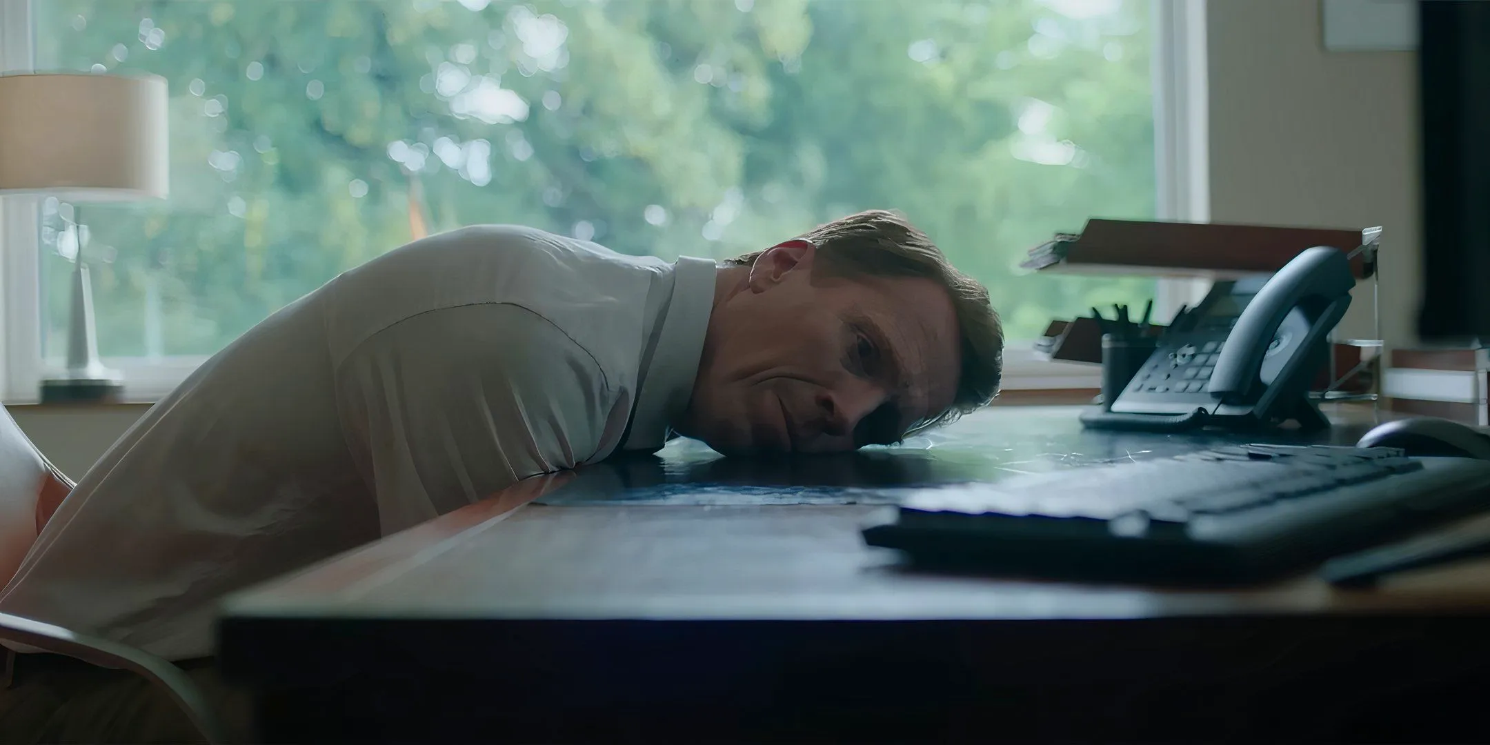 Damian Lewis as Peter looking stoic and laying his head on his desk in The Radleys Image