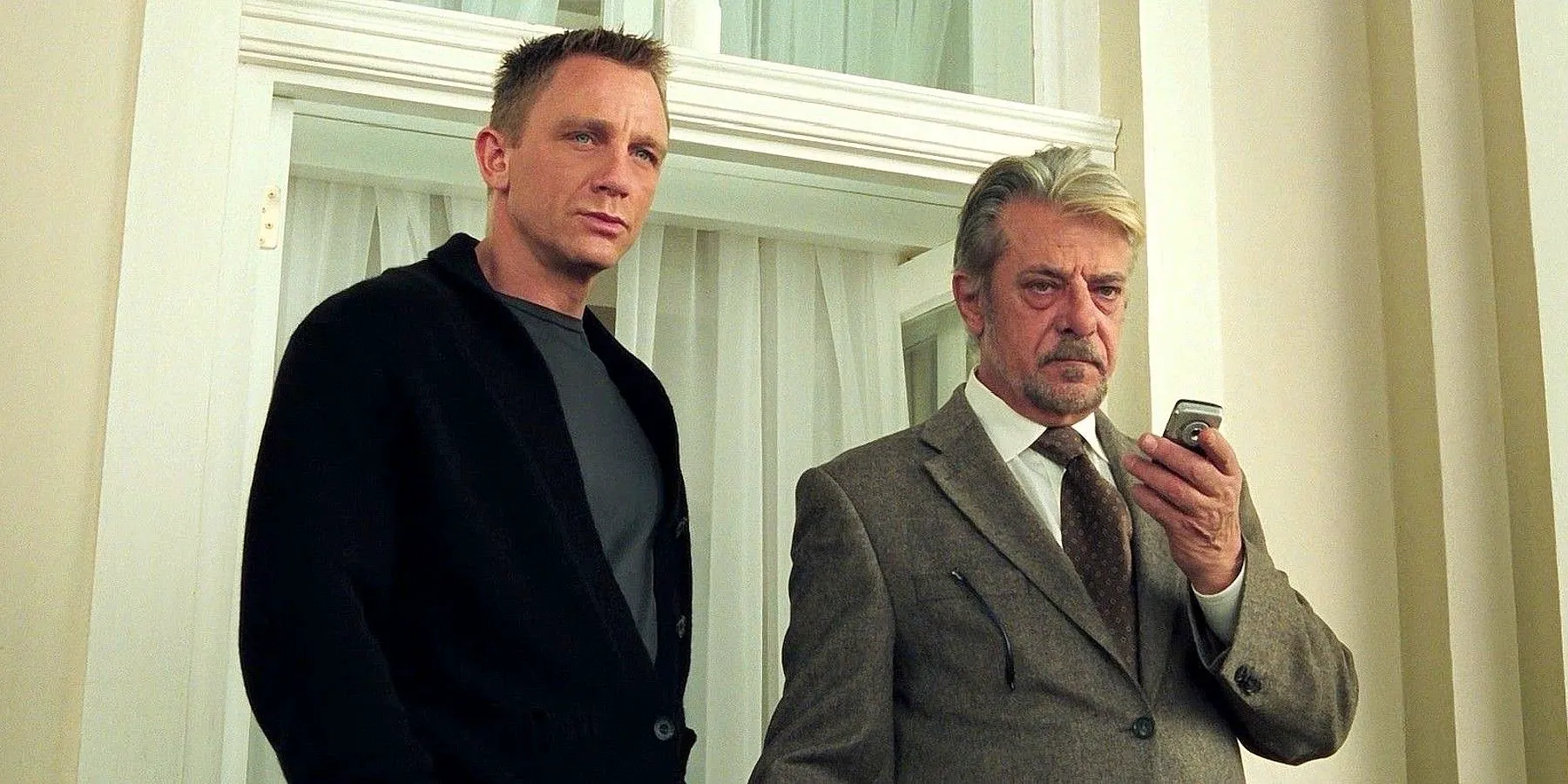 Daniel Craig's Bond and Giancarlo Giannini's René Mathis standing next to each other and looking upset in Casino Royale Image