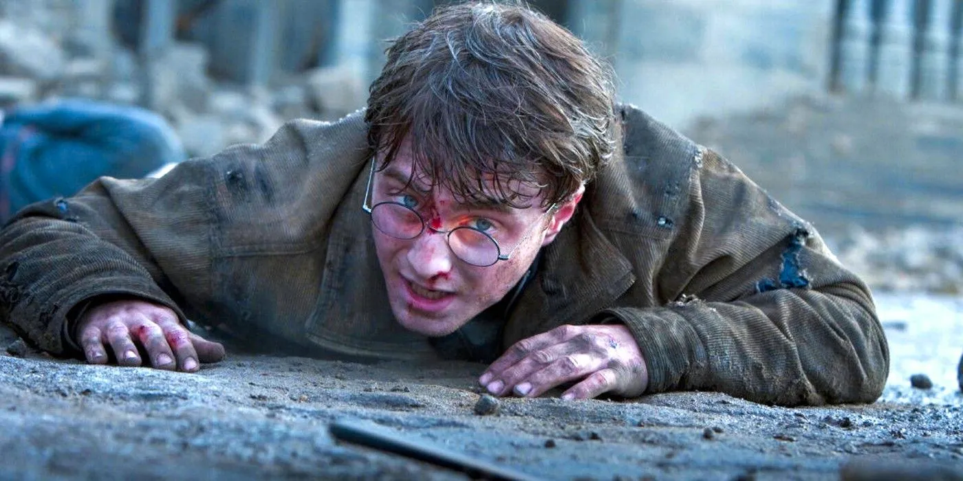 Daniel Radcliffe as Harry Potter on the ground looking at his wand in Harry Potter and the Deathly Hallows Image