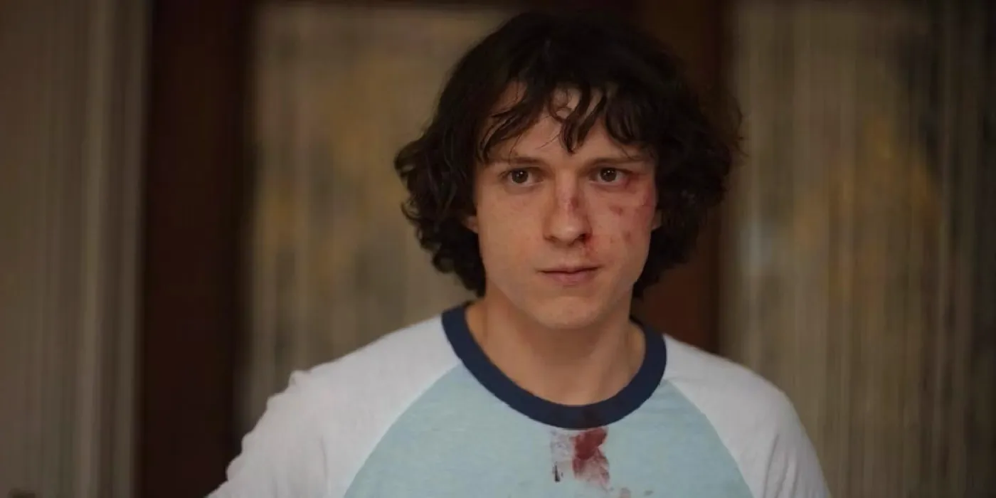 Danny (Tom Holland) with a bruised and bloody face in The Crowded Room. Image