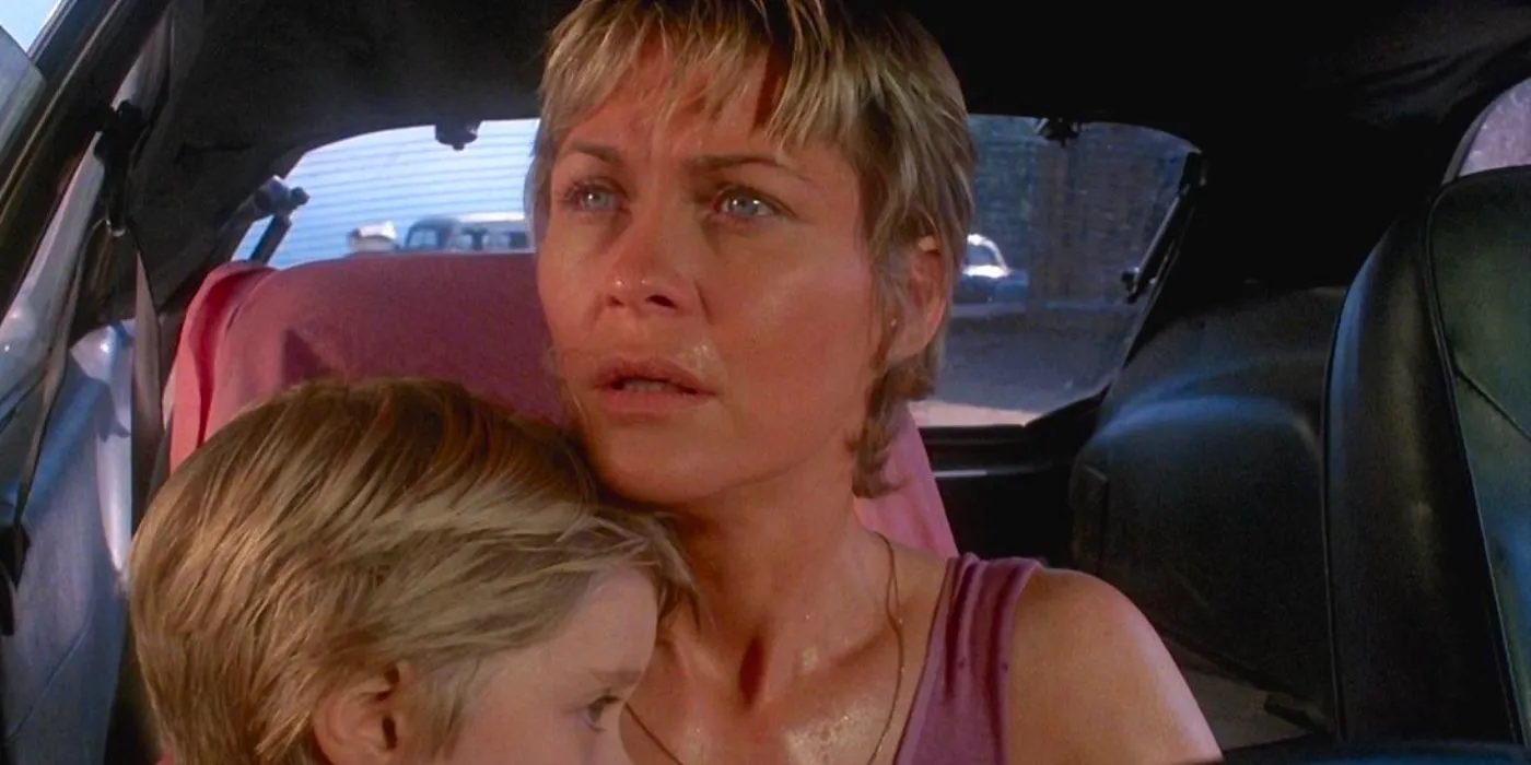 Dee Wallace as Donna Trenton looking scared in Cujo and holding her son Tad Image