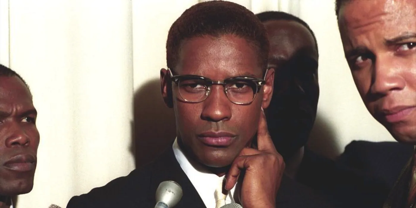 Denzel Washington as Malcolm X is surrounded by reporters of Nation of Islam members in Malcolm X. Image