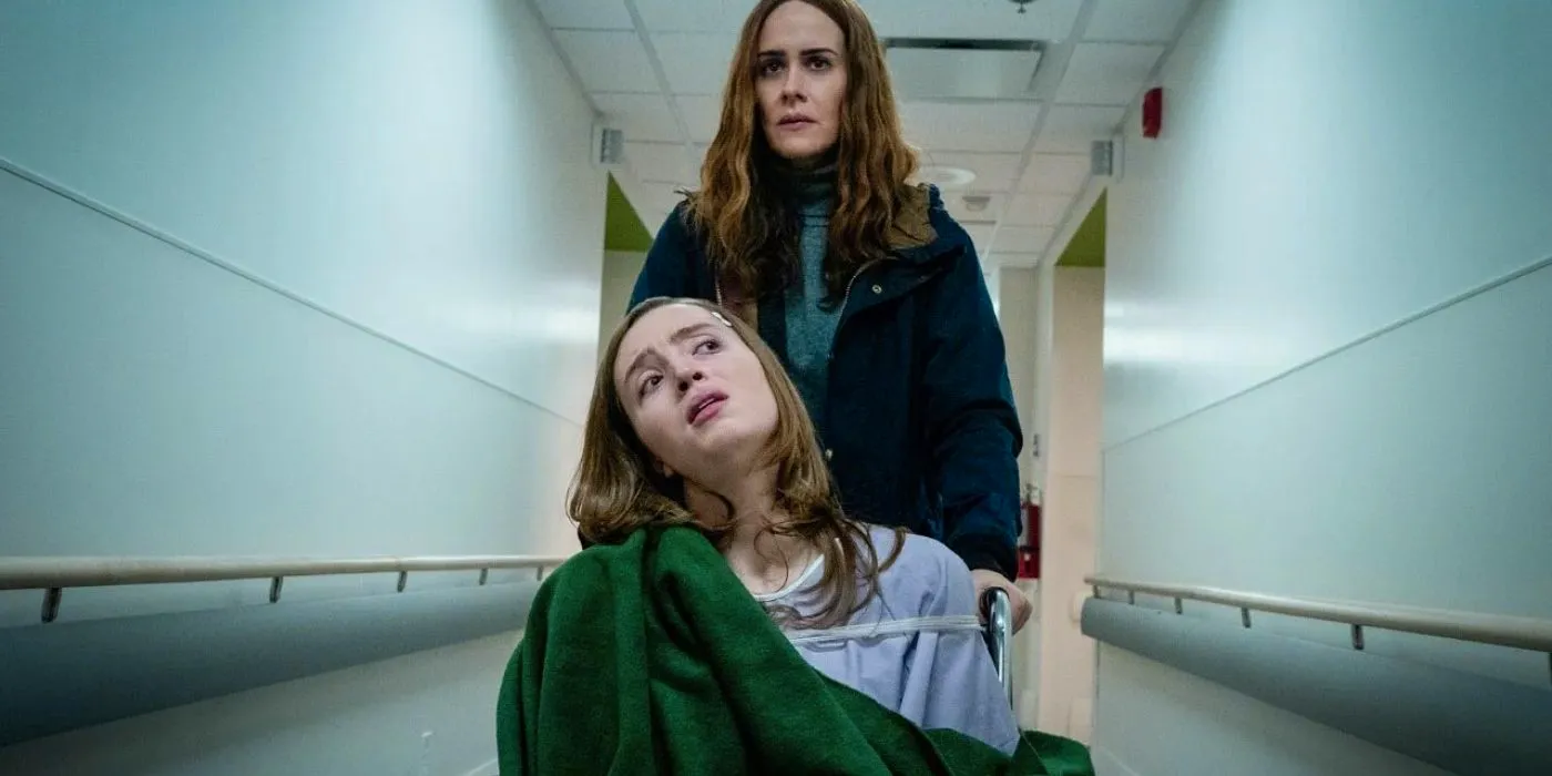 Diane pushing Chloe in a wheelchair in a hallway in Run Image