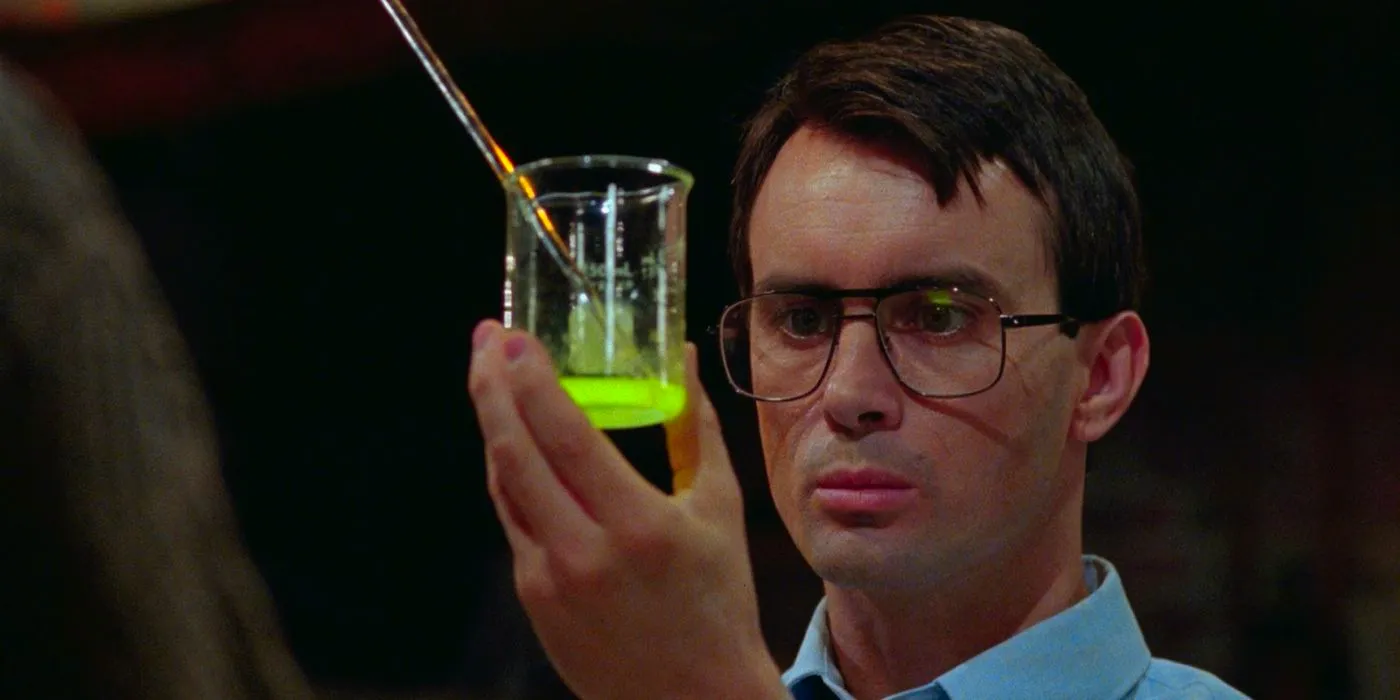 Dr. Herbert West (Jeffrey Combs) holding up a glowing green serum in Bride of Re-Animator. Image