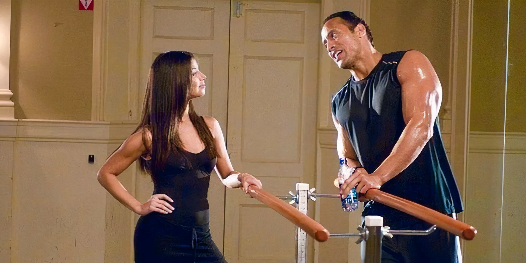 Dwayne Johnson and Roselyn Sanchez at a barre in a dance studio in The Game Plan Image