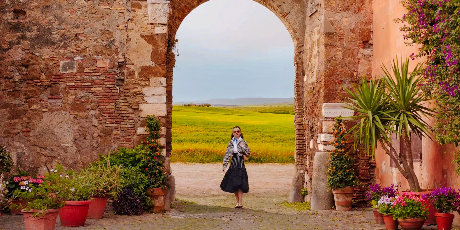 Emily walking through an arch in Emily in Paris Season 4 Episode 10 Image