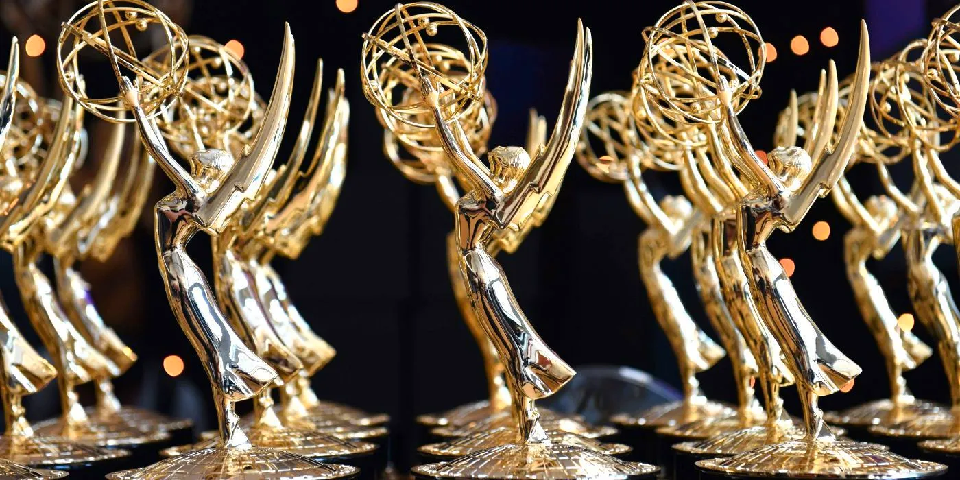 Emmys trophies lined up against a black background Image