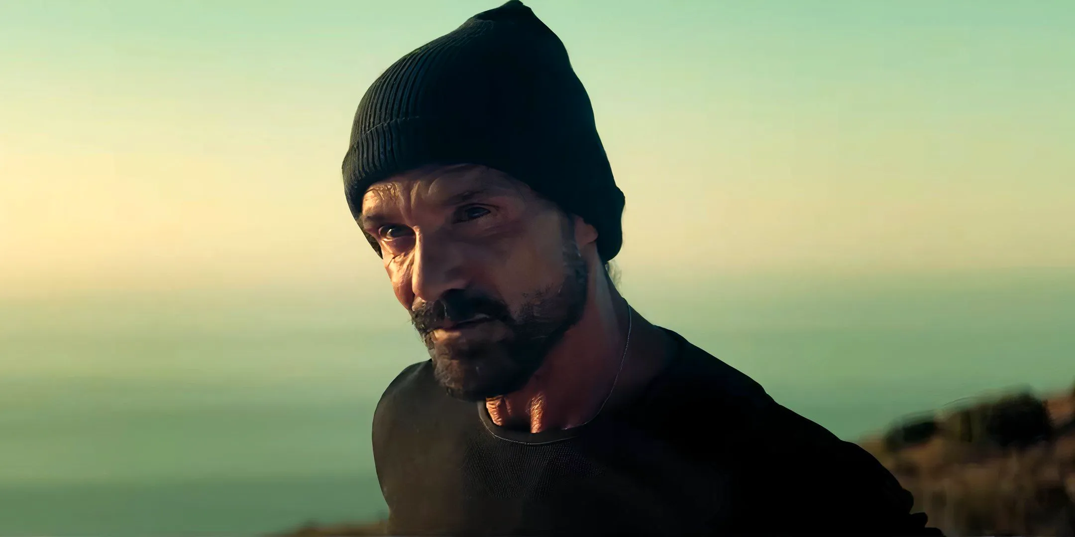 Frank Grillo standing near a cliff and looking angry in Long Gone Heroes Image