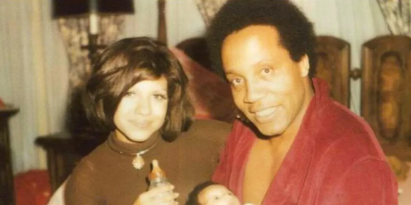 Frank Lucas sitting with his wife and baby. Image