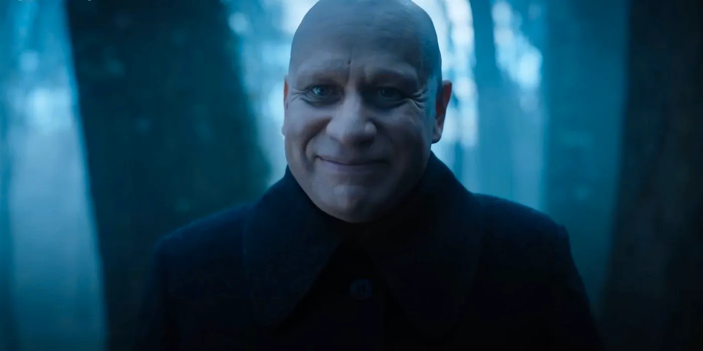 Fred Armisen as Uncle Fester smiling in Wednesday. Image