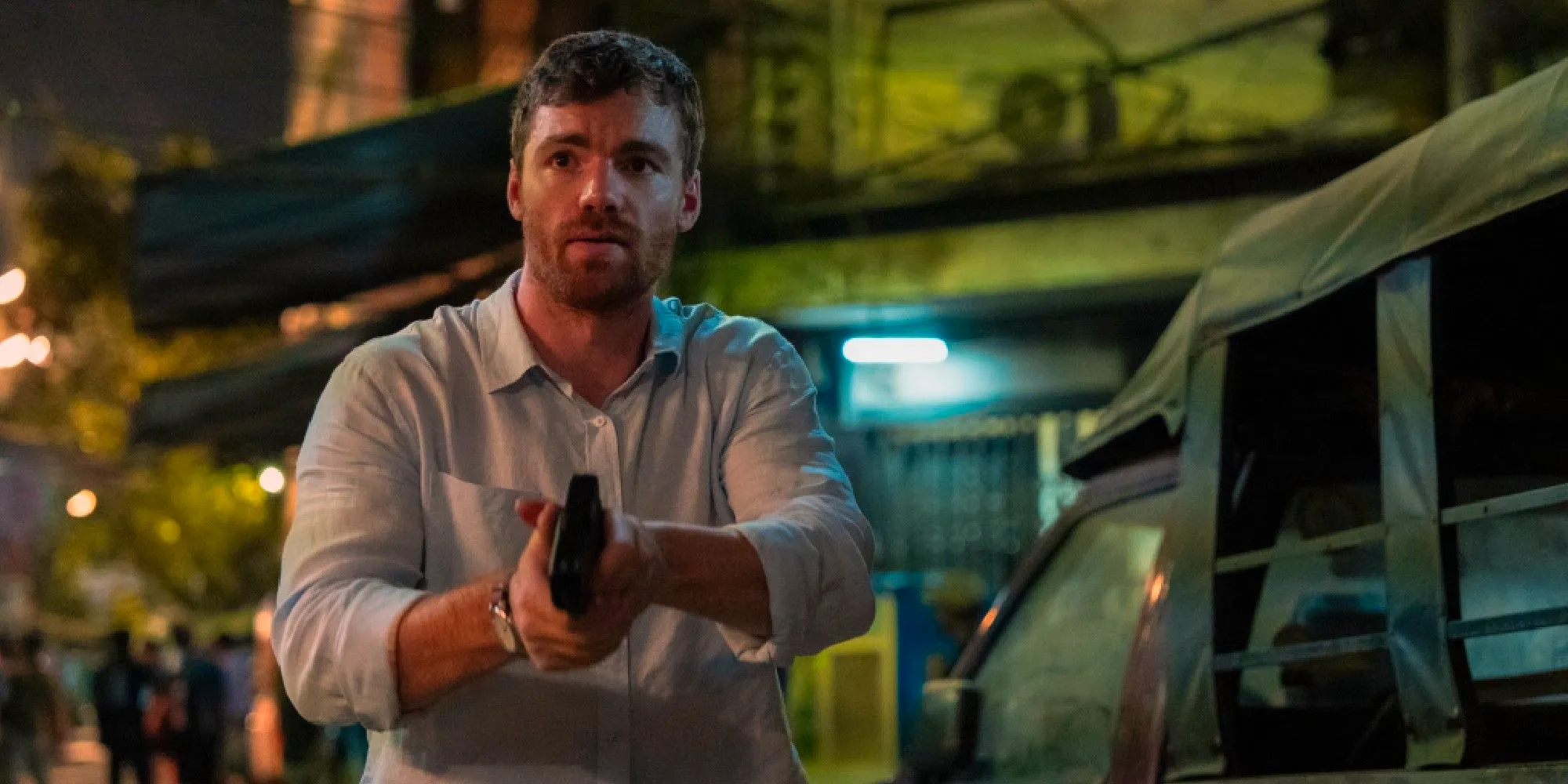 Gabriel Basso as Peter Sutherland holding a gun in The Night Agent season 2 Image