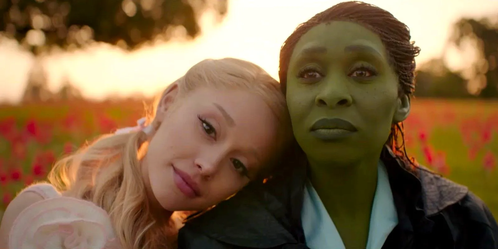 Galinda (Ariana Grande) leans her head on Elphaba (Cynthia Erivo)'s shoulder in the Wicked movie trailer. Image