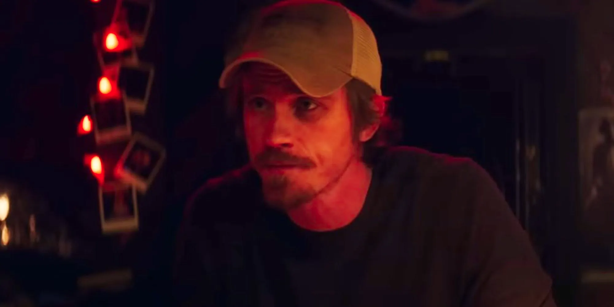 Garrett Hedlund wears a trucker hat and looks concerned in a scene from Tulsa King Image