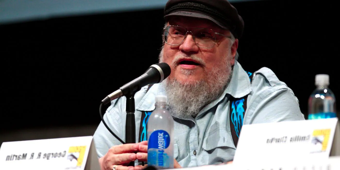 George R R Martin, wearing a hat, speaking at San Diego Comic-Con Image