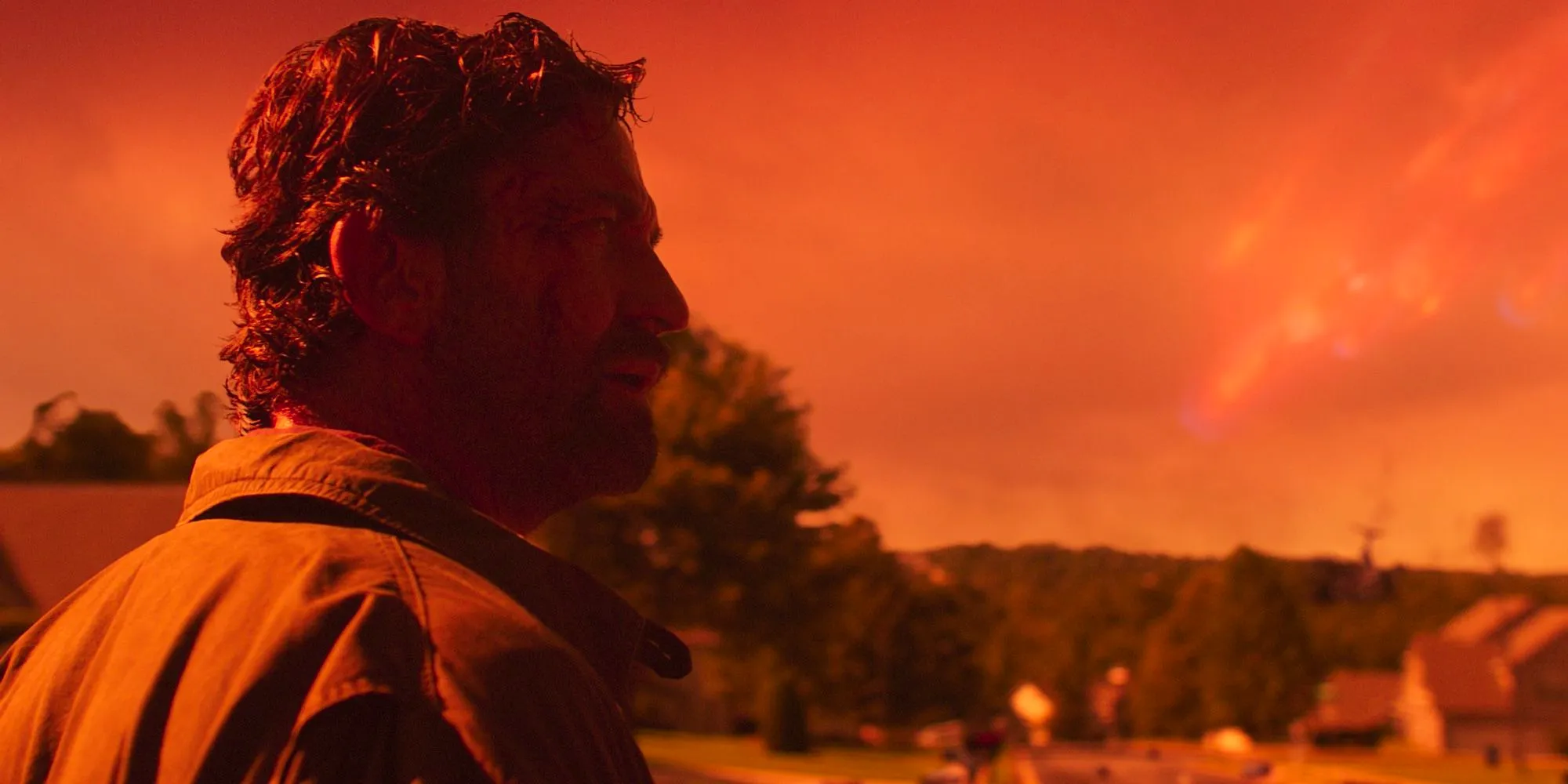 Gerard Butler is framed against a yellow sky looking dazed in Greenland Image