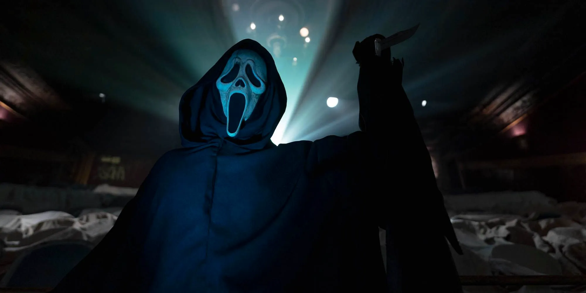 Ghostface with a knife raised in a theater in Scream 6 Image