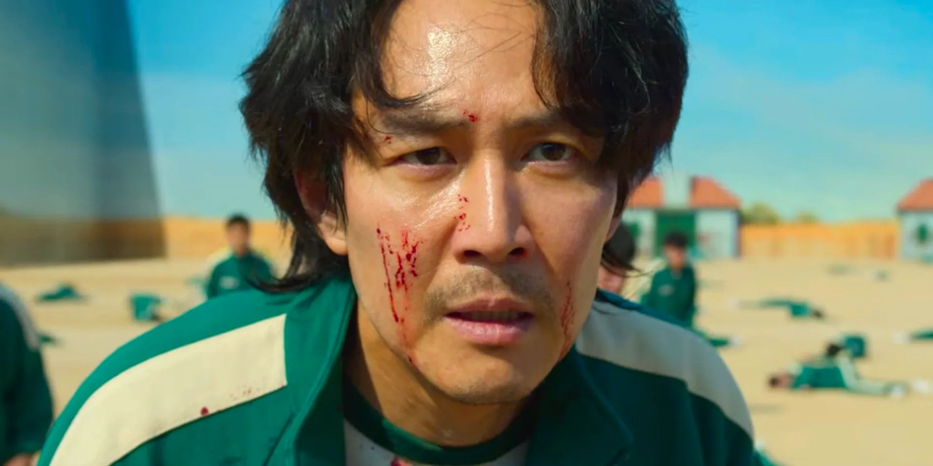 Gi-hun looking on intensely with blood on his face in Squid Game season 1 Image