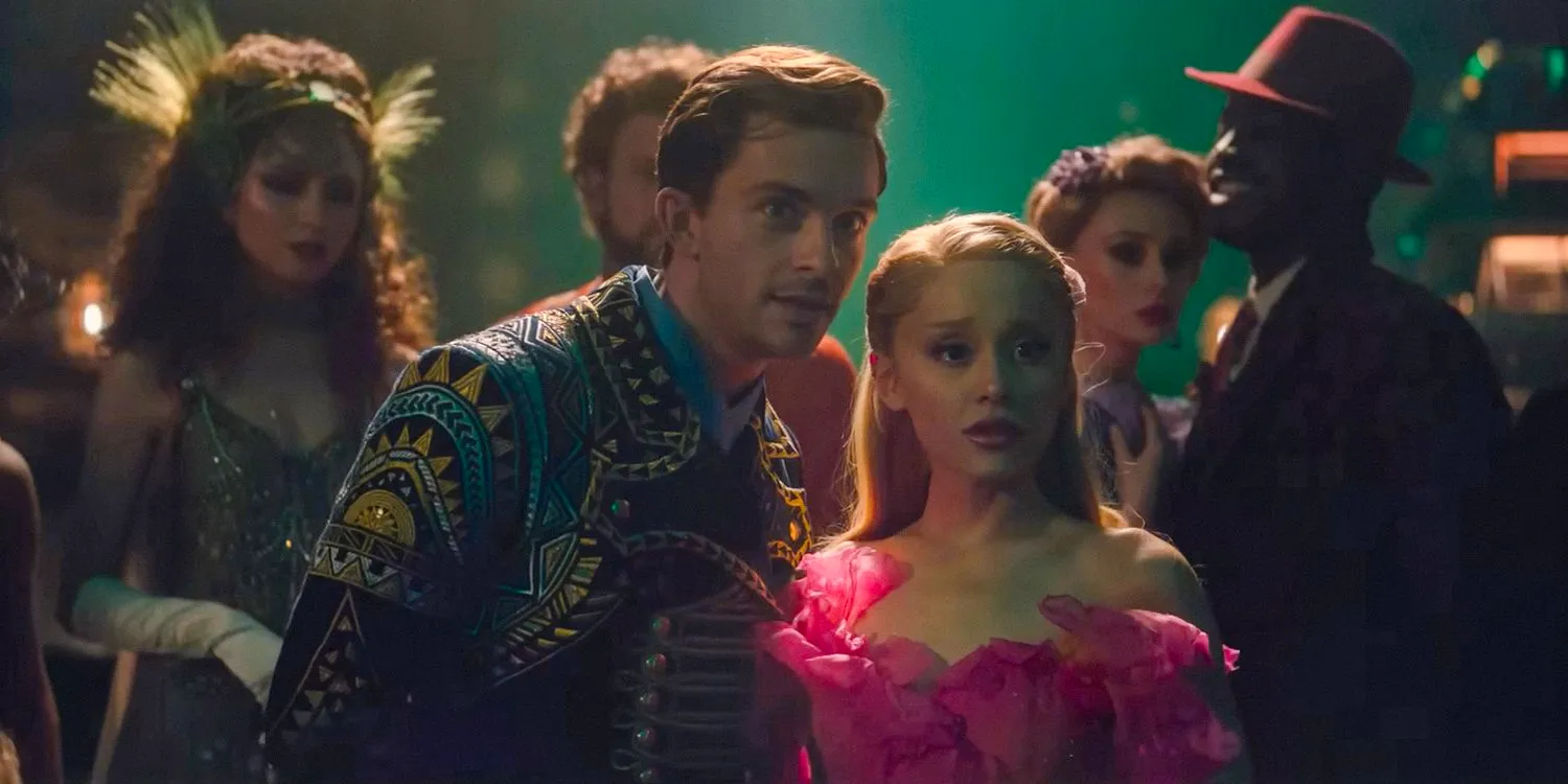 Glinda (Ariana Grande) and Fiyero (Jonathan Bailey) looking at something in Wicked. Image