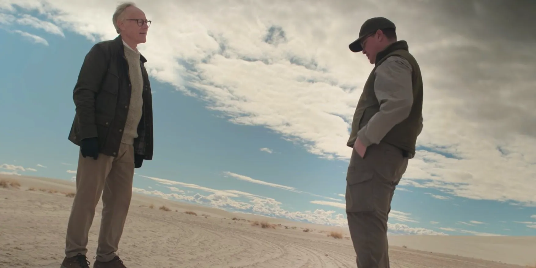 Graham Hancock Ancient Apocalypse speaking to someone while standing on the white sands Image