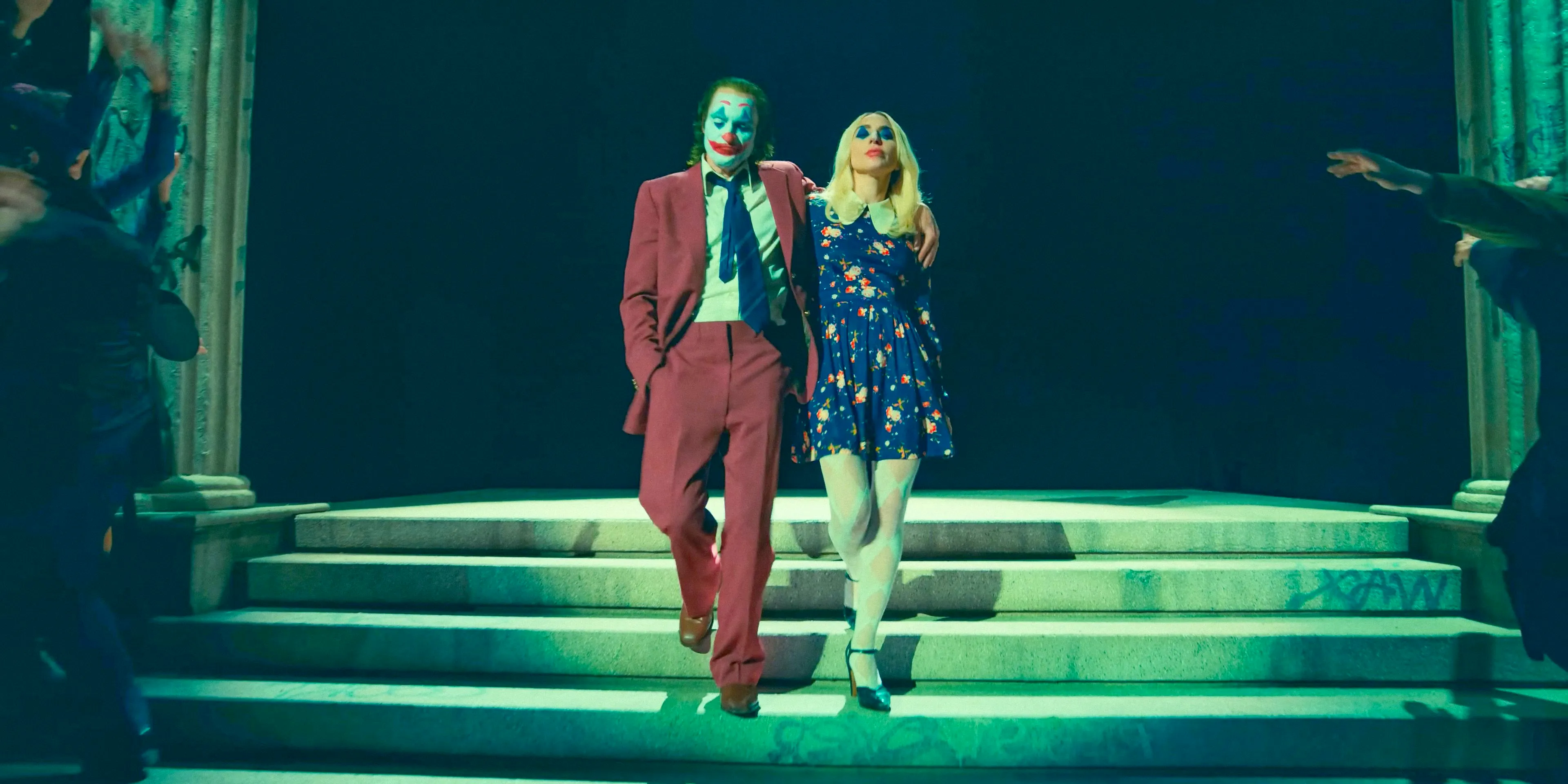 Harley Quinn (Lady Gaga) and Joker (Joaquin Phoenix) in an arrogant attitude leaving the court in Joker: Folie à Deux Image