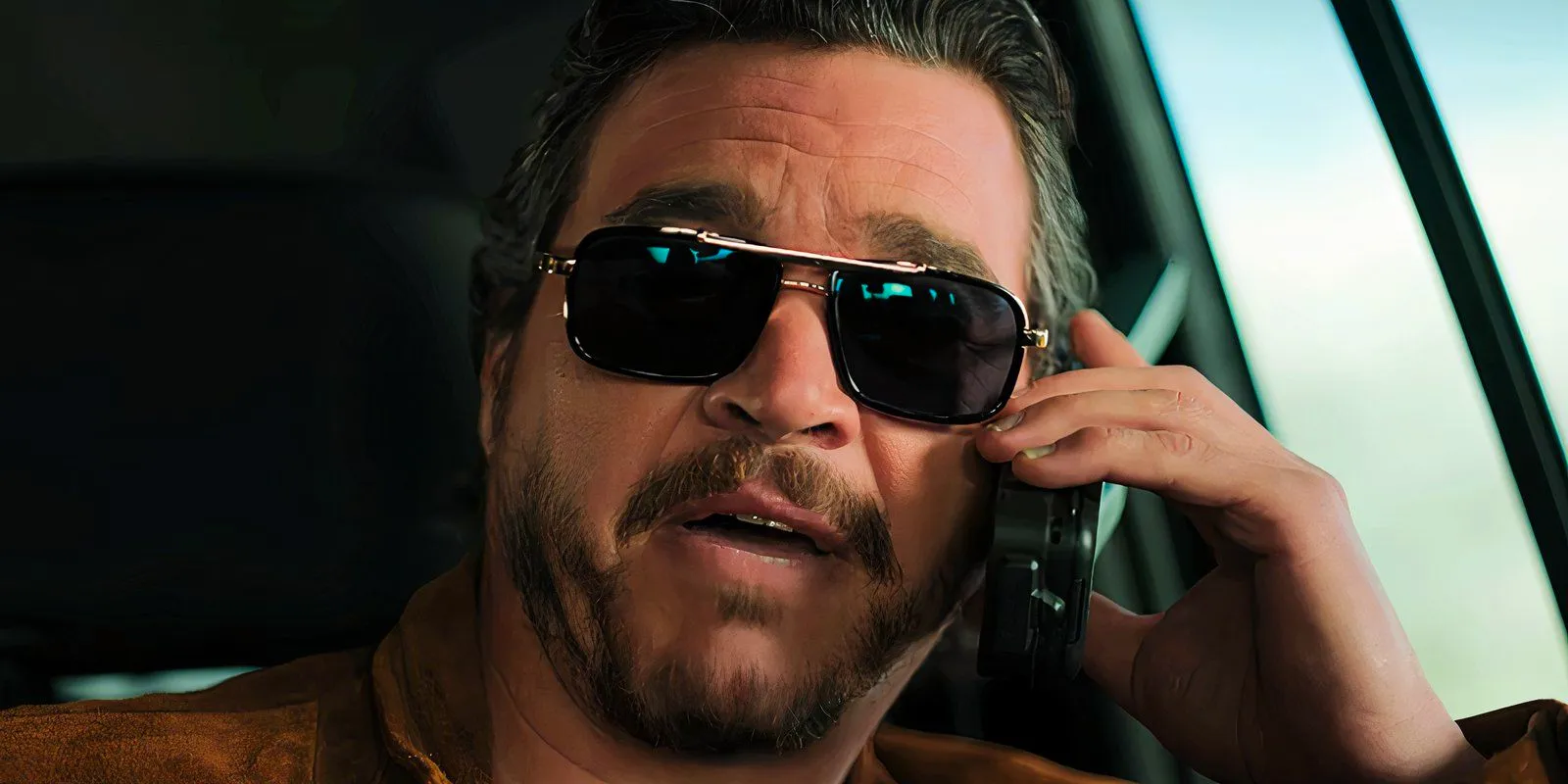 Hector Moya wears sunglasses and talks on the phone in The Lincoln Lawyer season 3 Image