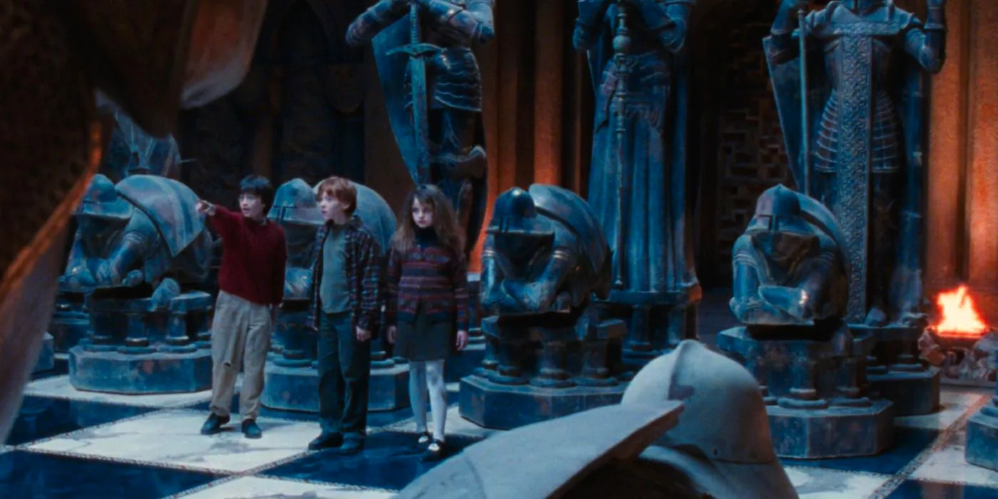 Hermione (Emma Watson), Ron (Rupert Grint), and Harry (Daniel Radcliffe) poinnting at something on the chessboard in Harry Potter and the Sorcerer's Stone. Image