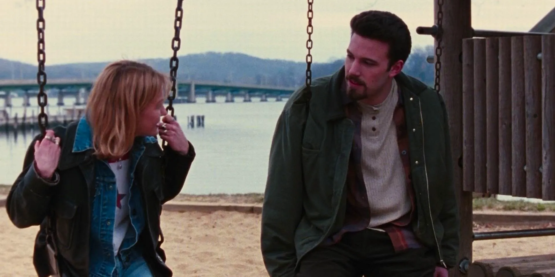 Holden and a girl talking while sitting on swings in Chasing Amy. Image