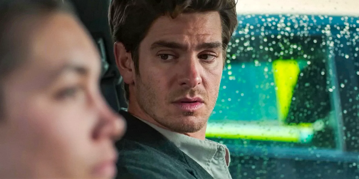 In a car, Tobias (Andrew Garfield) looks worriedly at Almut in We Live in Time Image