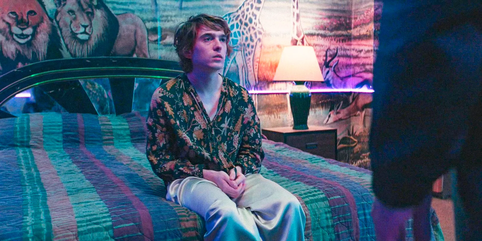 In a hotel room, Kid (Austin Abrams) sitting on the bed in WOLFS Image