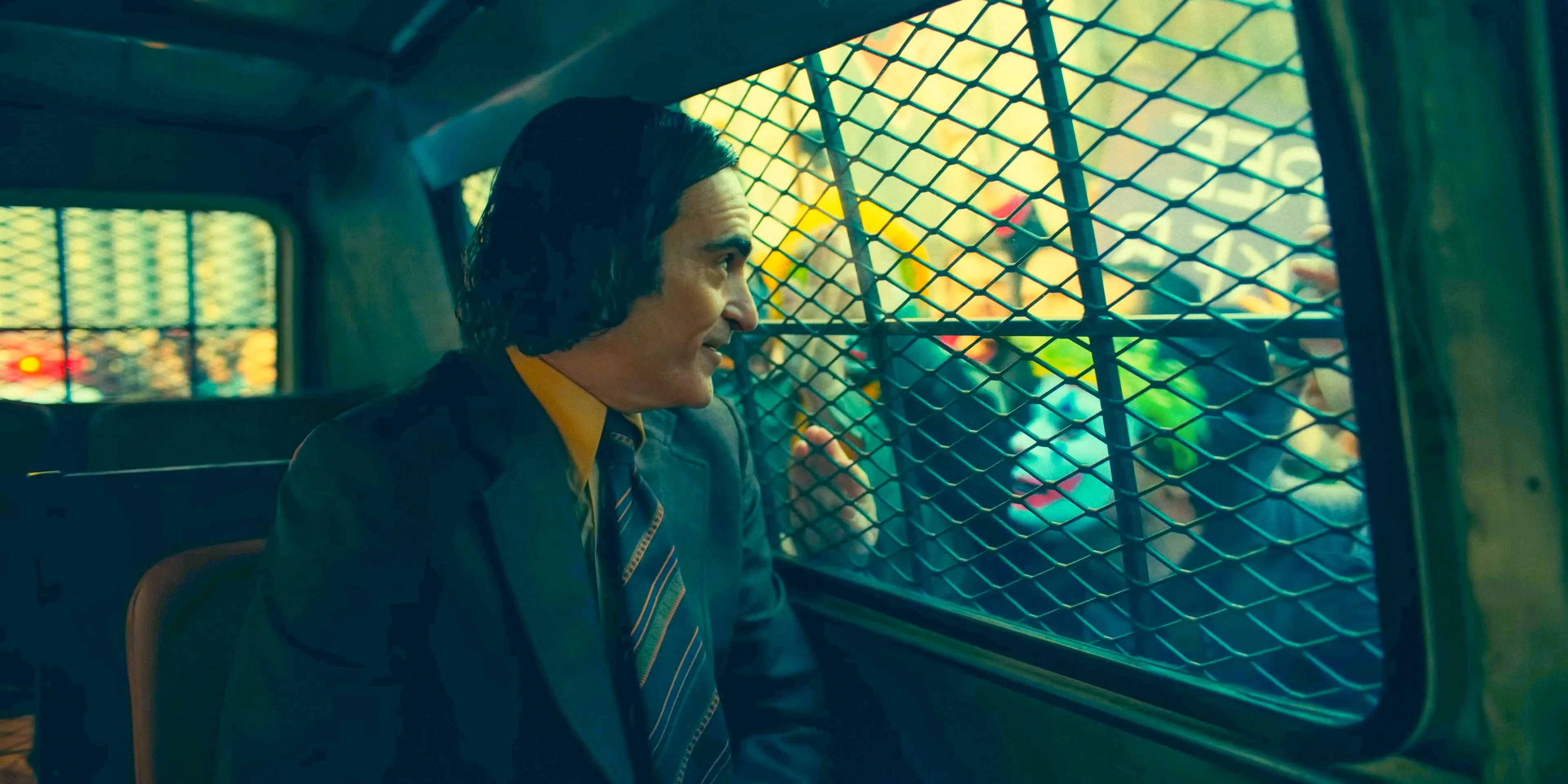 In a security van surrounded by fans, Arthur Fleck (Joaquin Phoenix) is being transferred to prison in Joker: Folie à Deux Image