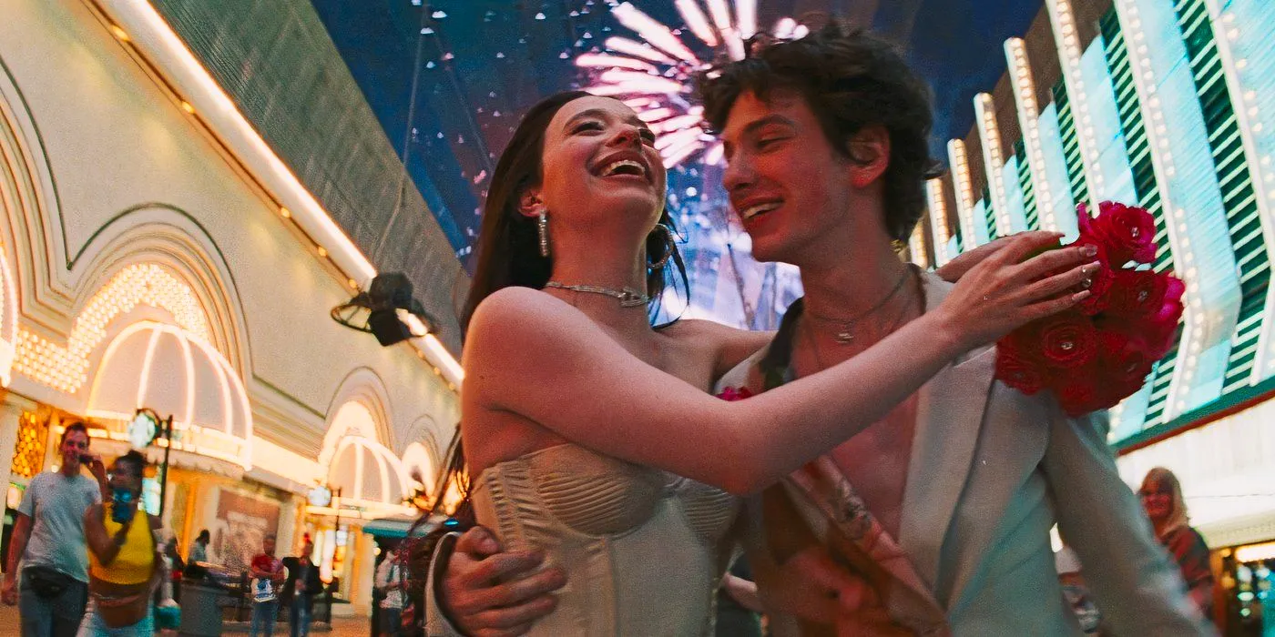 Ivan and Anora hugging while walking around in Vegas with fireworks in the background in Anora Image