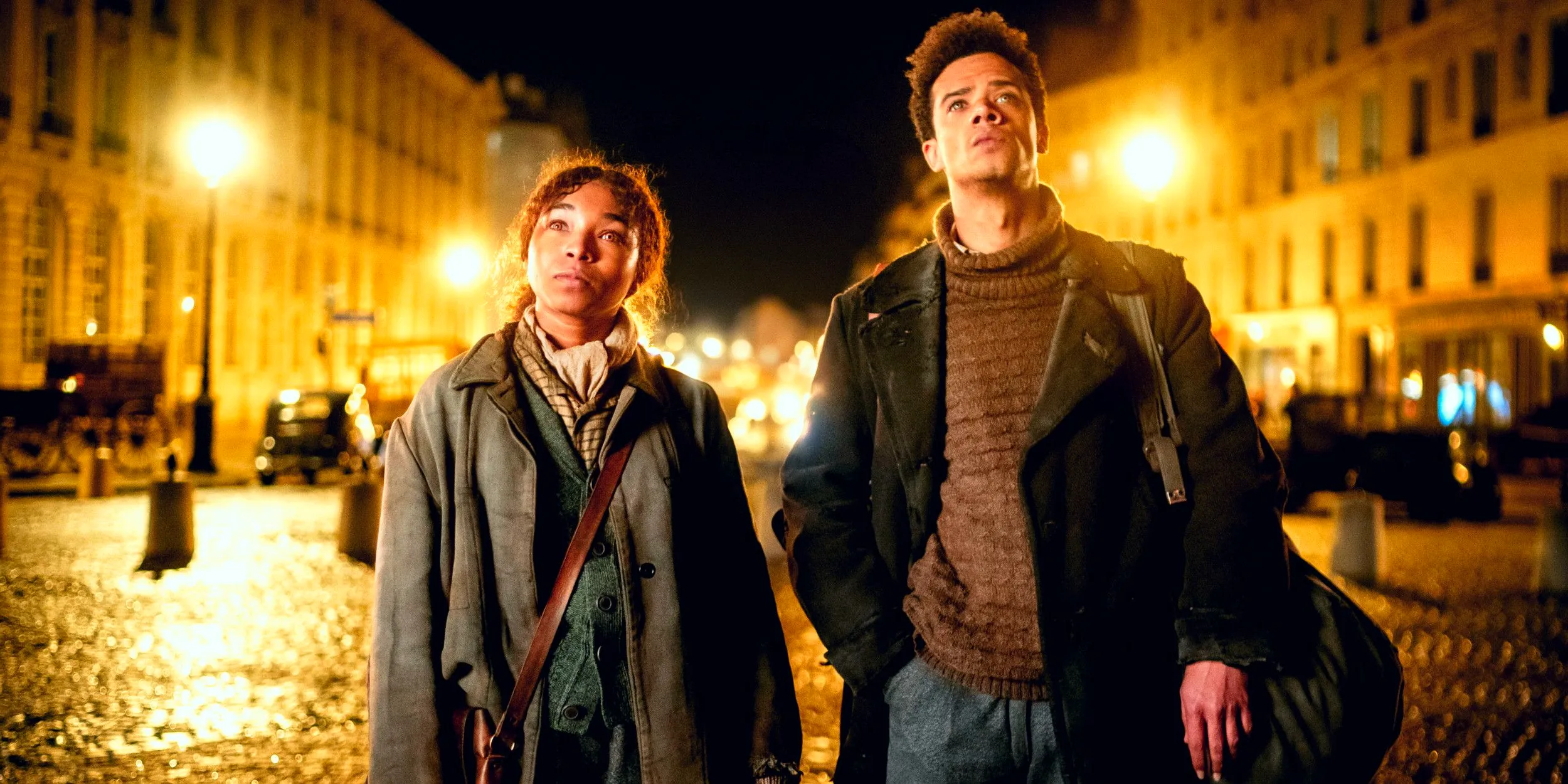 Jacob Anderson as Louis and Delainey Hayles as Claudia looking up while standing in the streets of Paris in Interview with the Vampire season 2 Image