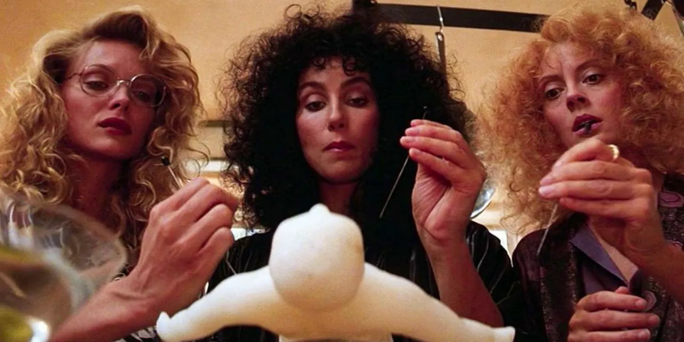 Jane, Alex, and Sukie stab a wax doll with needles in The Witches of Eastwick Image