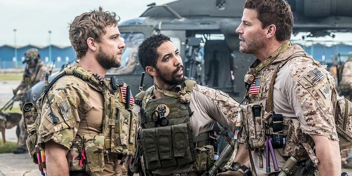 Jason, Ray and Clay argue in uniform in front of a helicopter in SEAL Team  Image