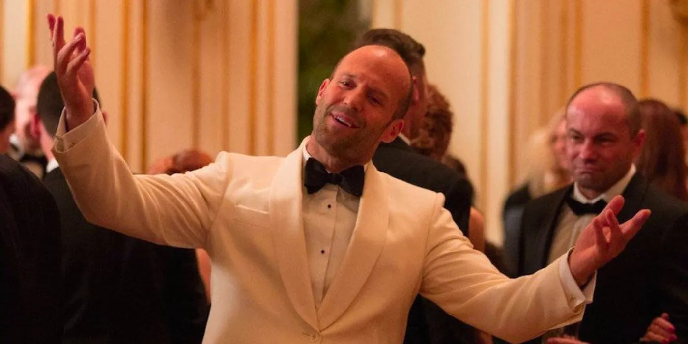 Jason Statham wearing a white suit and smiling in Spy Image