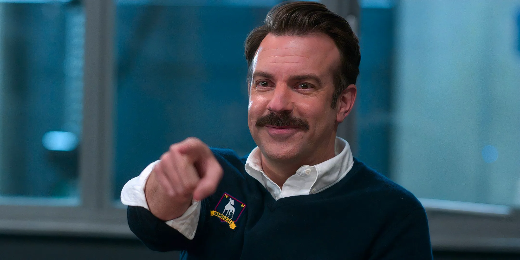 Jason Sudeikis as Ted Lasso smiling and pointing in Ted Lasso Image