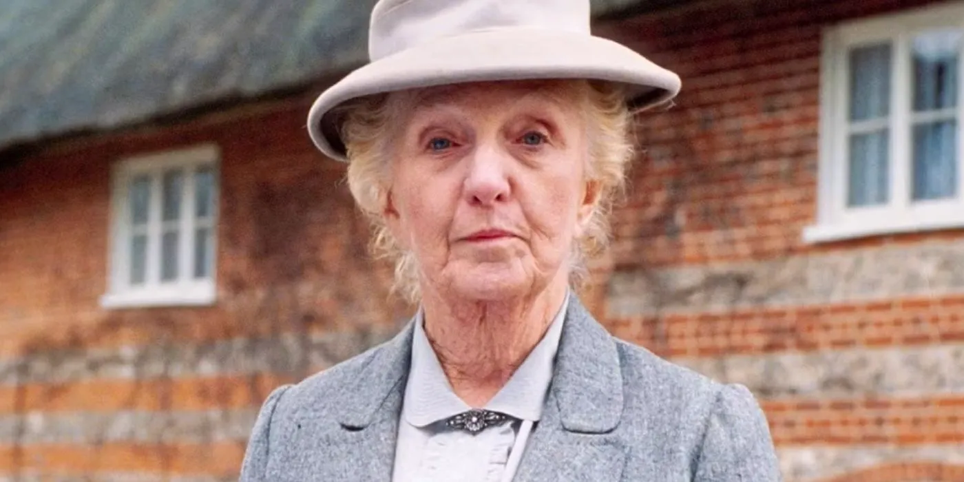 Joan Hickson as Miss Marple outside the brick of an estate Image