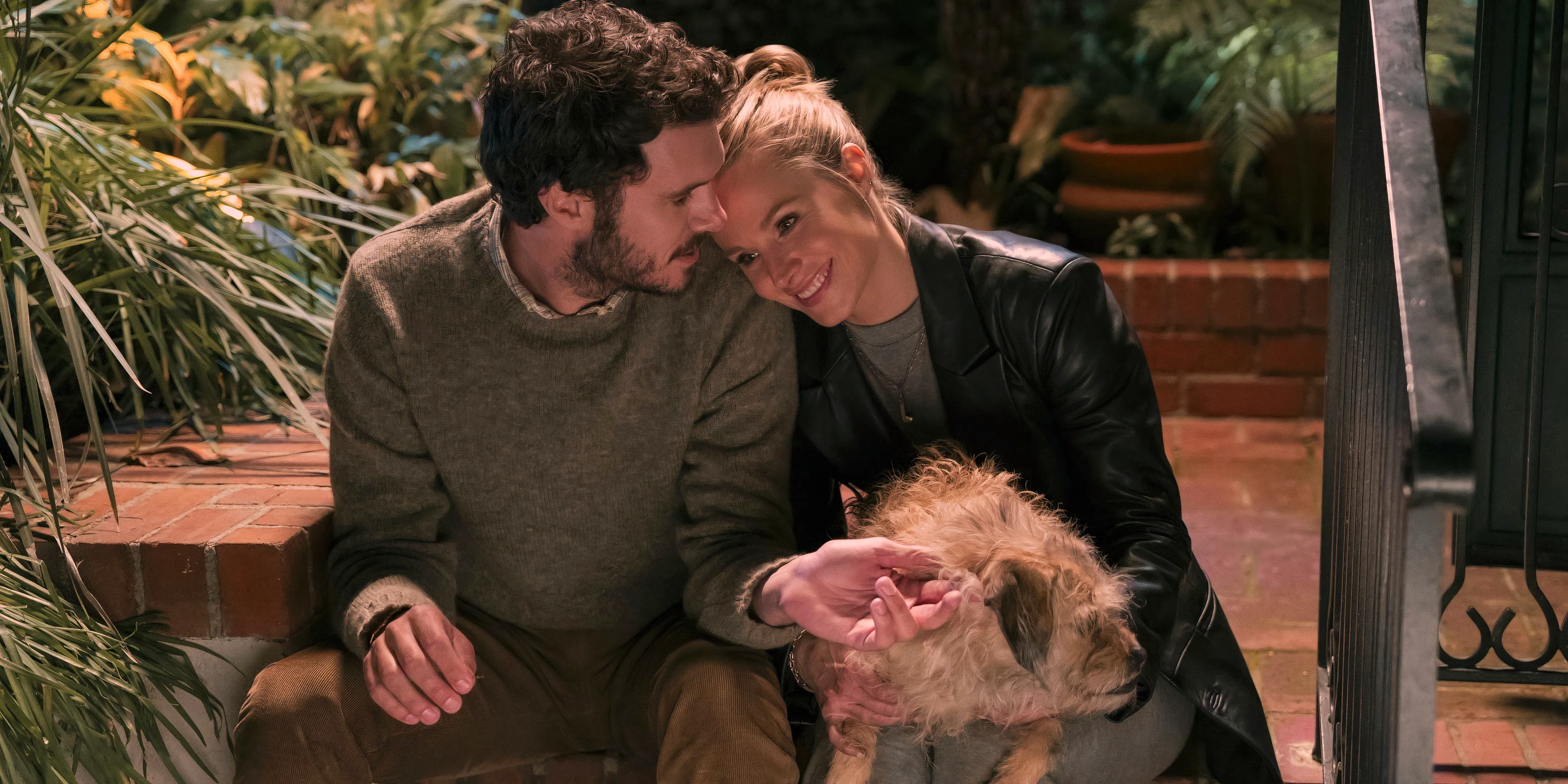 Joanne lays her head on Noah's shoulder while holding a dog on her lap in Netflix's Nobody Wants This. Image