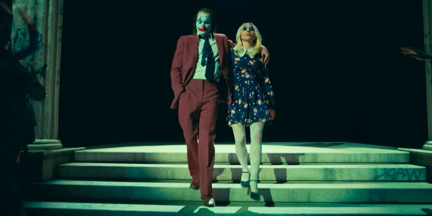 Joaquin Phoenix as Joker and Lady Gaga as Harley Quinn walking down stairs in Joker Folie à Deux Image