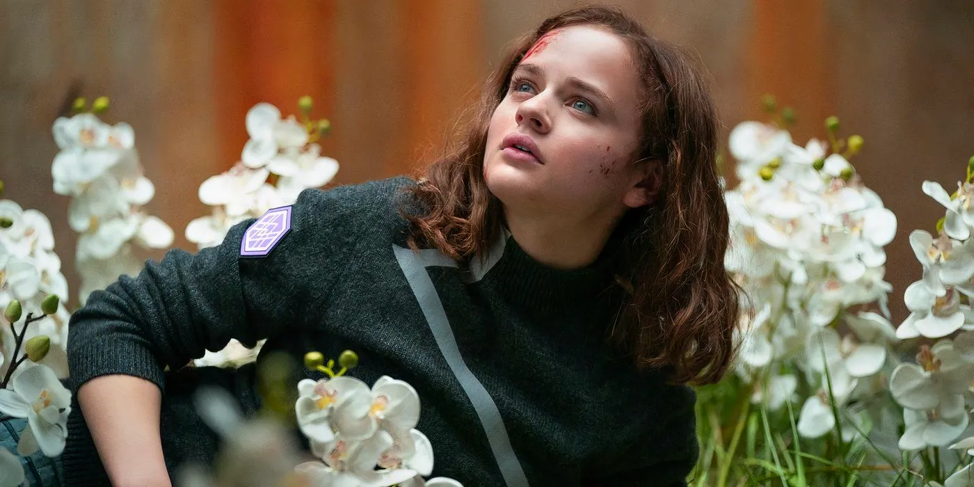 Joey King as Tally lying in a field of orchids in Uglies Image