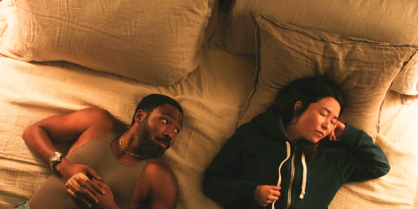 John (Donald Glover) looking over at Jane (Maya Erskine) while laying in bed in Mr. & Mrs. Smith Image