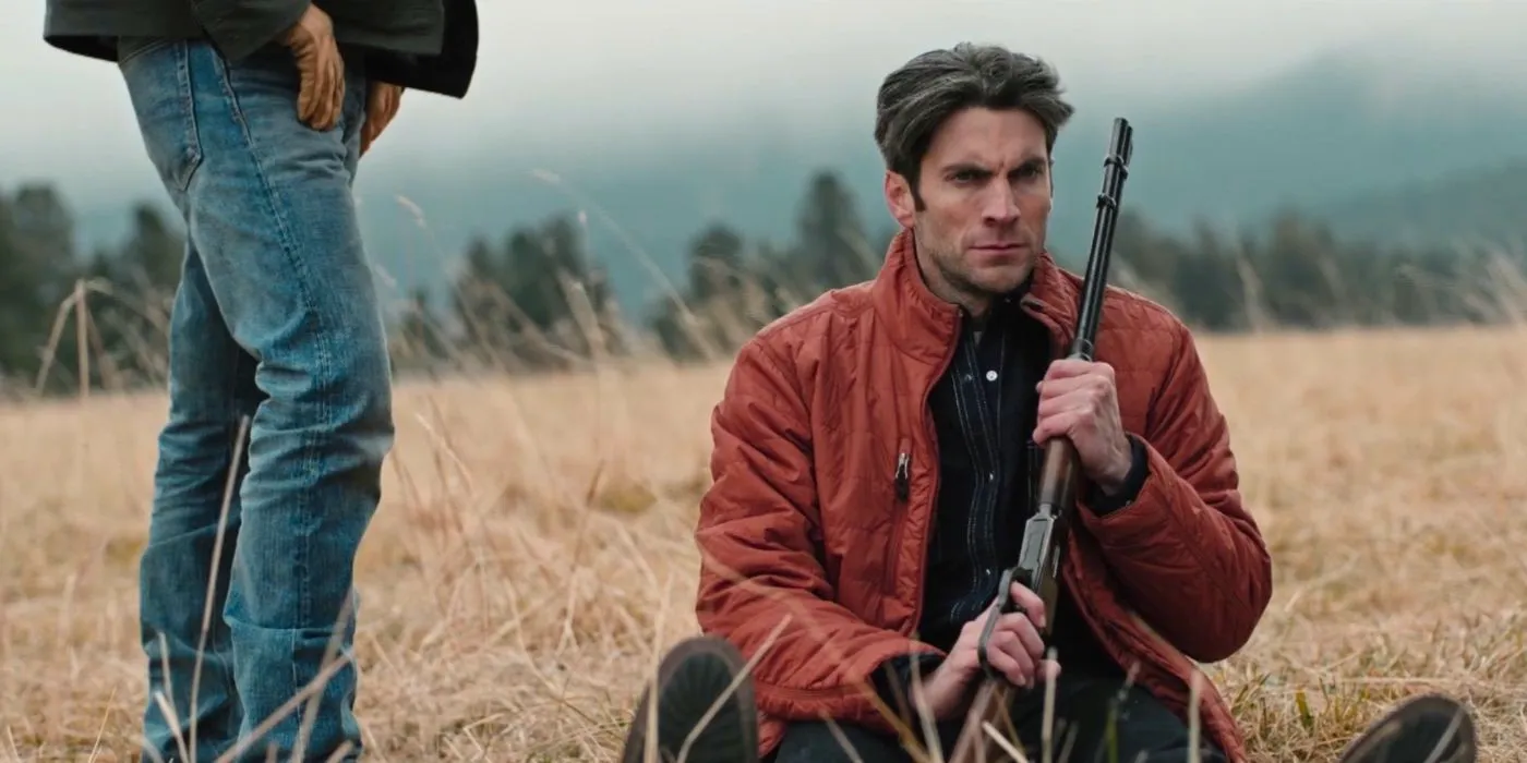 John (Kevin Costner) standing over Jamie (Wes Bentley) as he holds a gun in Yellowstone. Image