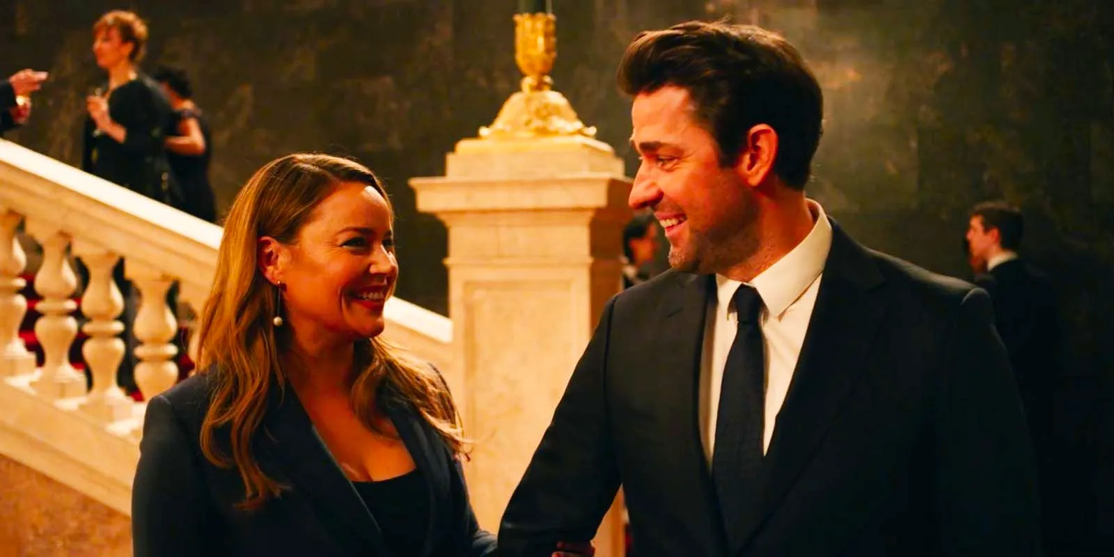 John Krasinski as Jack Ryan and Abbie Cornish as Cathy Mueller smiling at each other in Tom Clancy's Jack Ryan season 4 premiere Image